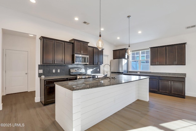 kitchen with dark brown cabinetry, visible vents, appliances with stainless steel finishes, and a sink