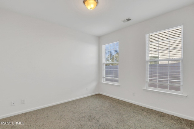 carpeted empty room featuring visible vents and baseboards