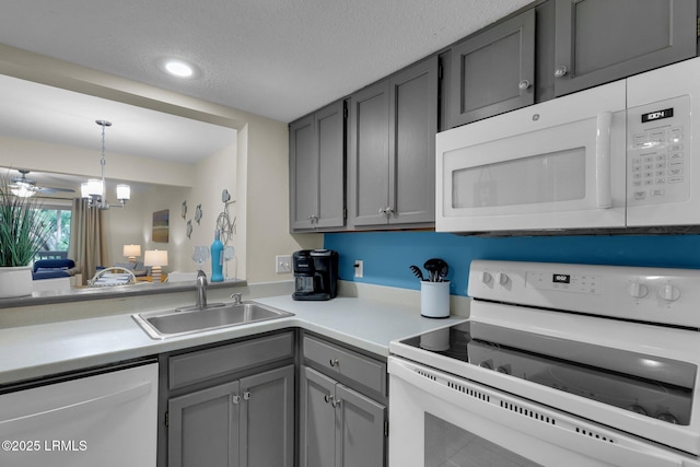 kitchen featuring gray cabinets, decorative light fixtures, sink, white appliances, and a textured ceiling