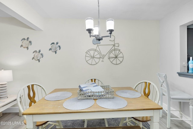 dining room with hardwood / wood-style floors and an inviting chandelier