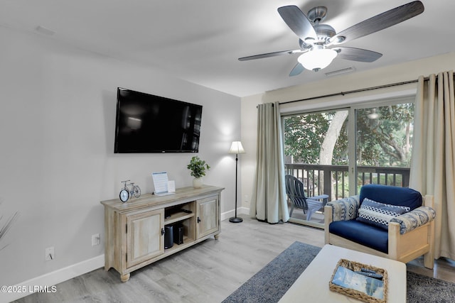 living room with light hardwood / wood-style flooring and ceiling fan