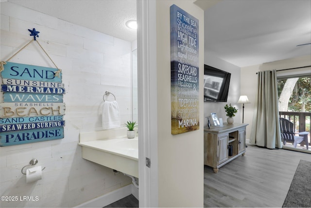 bathroom featuring hardwood / wood-style floors and a textured ceiling