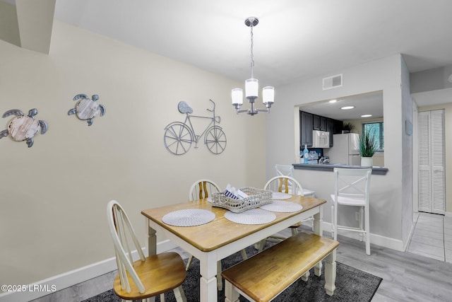 dining area featuring a notable chandelier and light hardwood / wood-style flooring