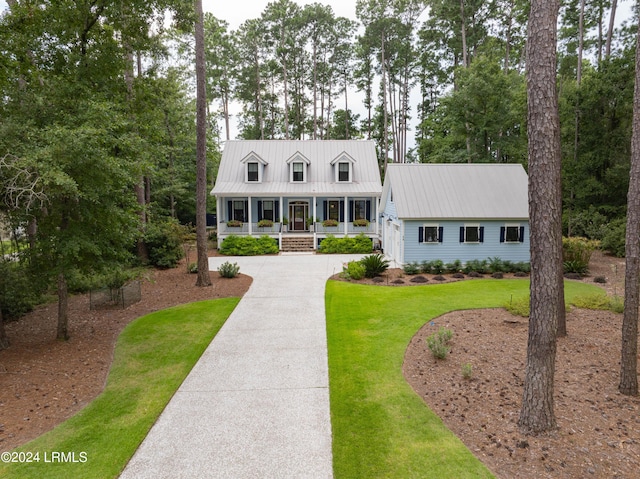 cape cod home featuring a porch, metal roof, and a front yard