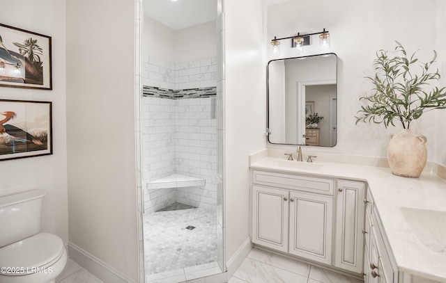 bathroom featuring vanity, toilet, and a tile shower