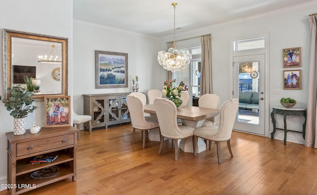 dining space featuring ornamental molding, a chandelier, and light wood-type flooring