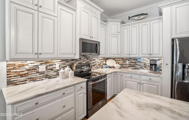 kitchen featuring crown molding, appliances with stainless steel finishes, decorative backsplash, and white cabinets