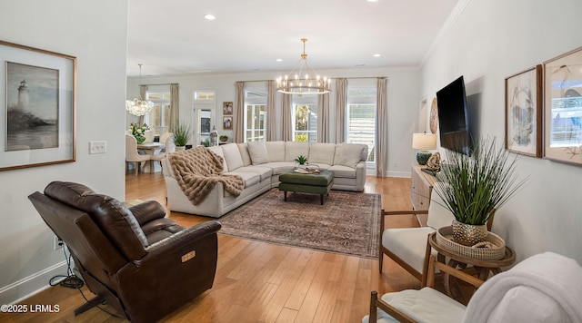 living room featuring crown molding, a chandelier, and light hardwood / wood-style floors