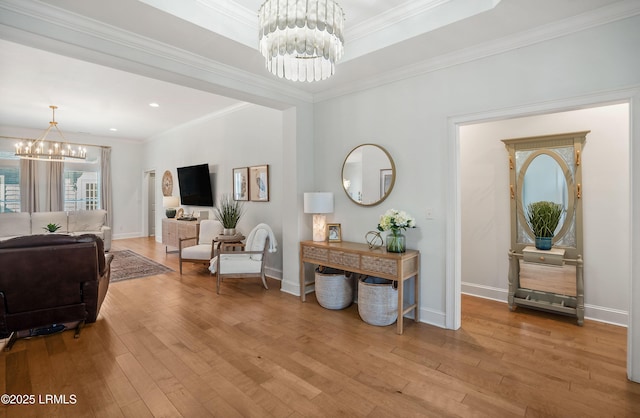 interior space featuring an inviting chandelier, ornamental molding, and light hardwood / wood-style floors