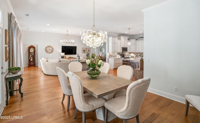 dining room with crown molding and light hardwood / wood-style flooring