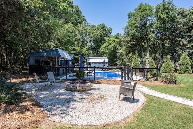 exterior space with an outdoor structure, a lawn, and an outdoor fire pit