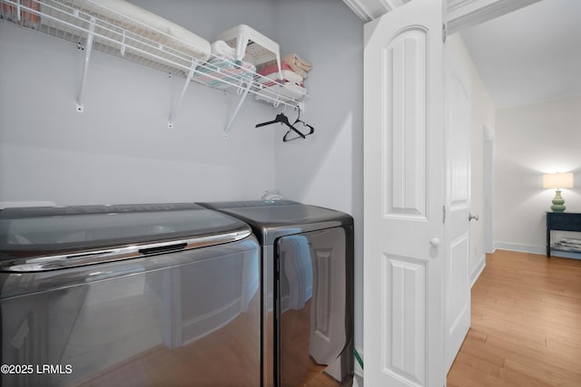 clothes washing area featuring washing machine and dryer and hardwood / wood-style floors