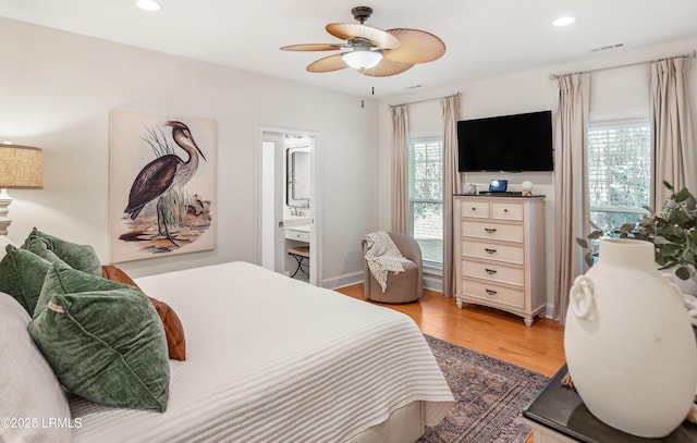 bedroom with ceiling fan, connected bathroom, and light hardwood / wood-style floors