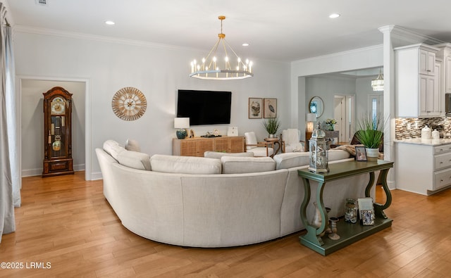 living room featuring crown molding, a notable chandelier, and light wood-type flooring