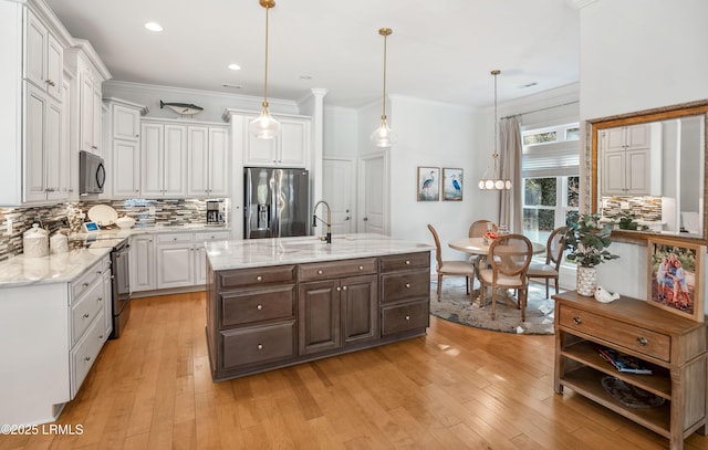 kitchen with stainless steel refrigerator with ice dispenser, white cabinetry, range with electric stovetop, an island with sink, and pendant lighting