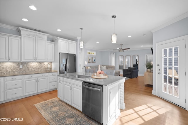 kitchen with an island with sink, appliances with stainless steel finishes, sink, and white cabinets