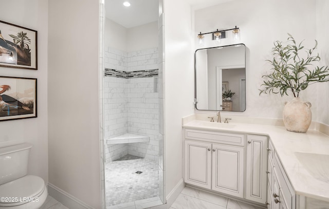 bathroom with vanity, a tile shower, and toilet