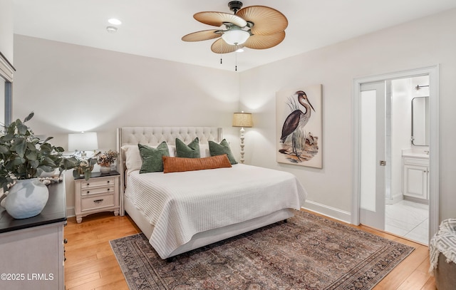 bedroom featuring ceiling fan, ensuite bath, and light hardwood / wood-style floors