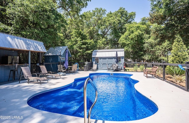 view of pool with an outbuilding, an outdoor bar, and a patio