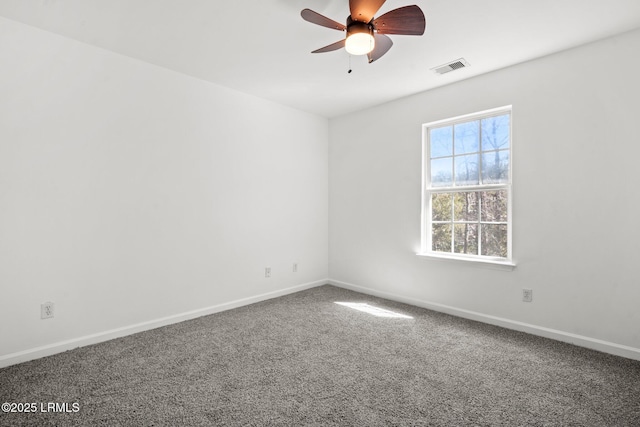 carpeted spare room featuring visible vents, baseboards, and ceiling fan