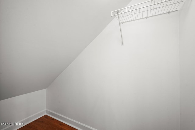 spacious closet featuring vaulted ceiling and dark wood-style flooring