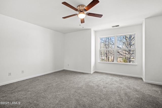 carpeted empty room with visible vents, ceiling fan, and baseboards