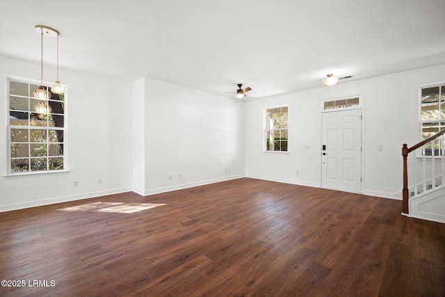 foyer featuring visible vents, baseboards, dark wood-style flooring, stairs, and ceiling fan with notable chandelier