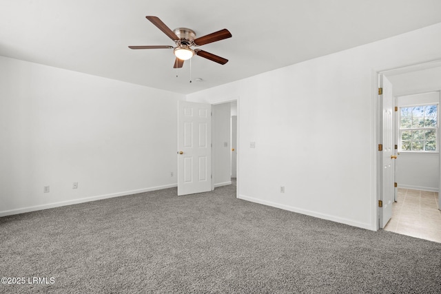 carpeted empty room with baseboards and a ceiling fan