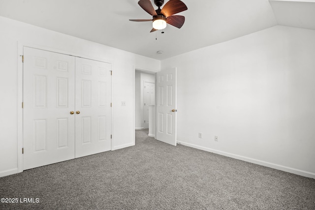 unfurnished bedroom featuring baseboards, carpet, vaulted ceiling, a closet, and a ceiling fan