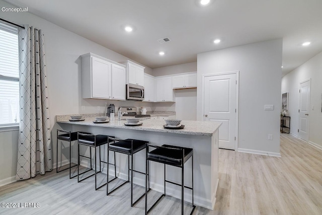 1530 Sanctum St, Ridgeland, SC 29936 - kitchen featuring appliances with stainless steel finishes, a peninsula, light wood-style flooring, white cabinetry, and recessed lighting