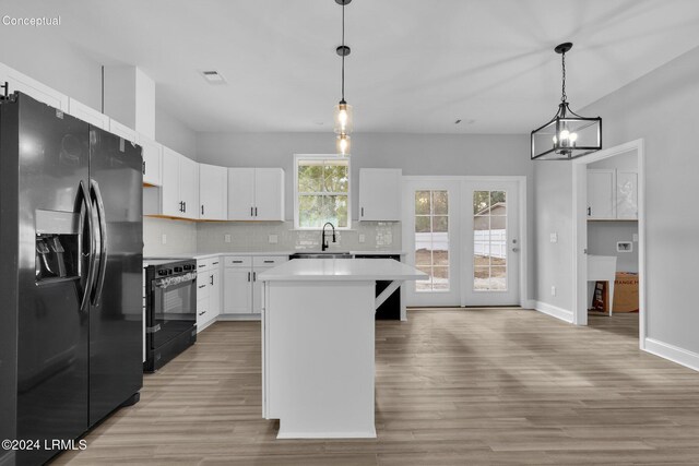 kitchen with pendant lighting, sink, white cabinetry, a center island, and black appliances