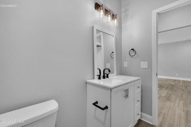 bathroom with vanity, hardwood / wood-style floors, and toilet