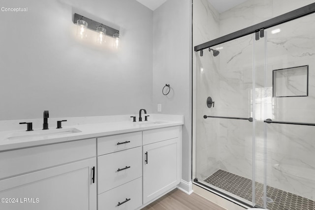 bathroom with hardwood / wood-style flooring, vanity, and walk in shower