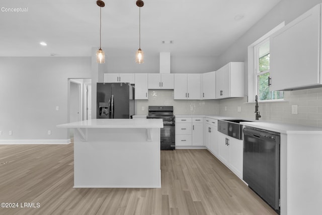 kitchen featuring tasteful backsplash, white cabinetry, a kitchen island, and black appliances