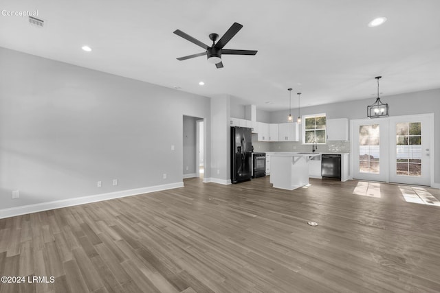 unfurnished living room featuring ceiling fan, wood-type flooring, and sink