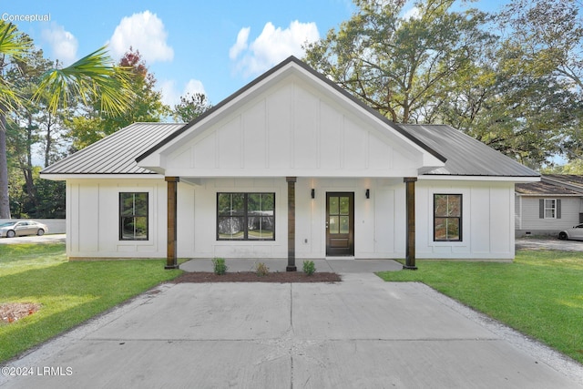 modern farmhouse featuring a front yard and covered porch