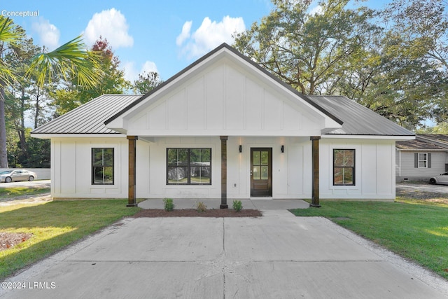 modern farmhouse style home featuring a front yard and covered porch