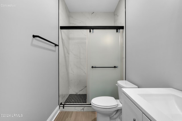 bathroom featuring vanity, hardwood / wood-style floors, a shower with shower door, and toilet