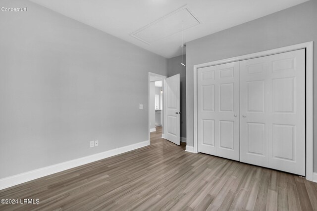 unfurnished bedroom featuring light hardwood / wood-style floors and a closet