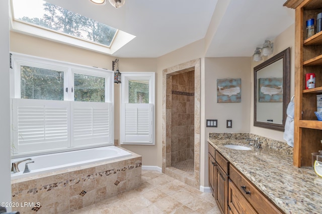 bathroom with vanity, a skylight, and separate shower and tub