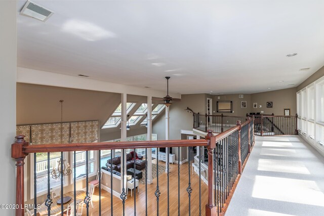 hallway featuring wood-type flooring and a notable chandelier