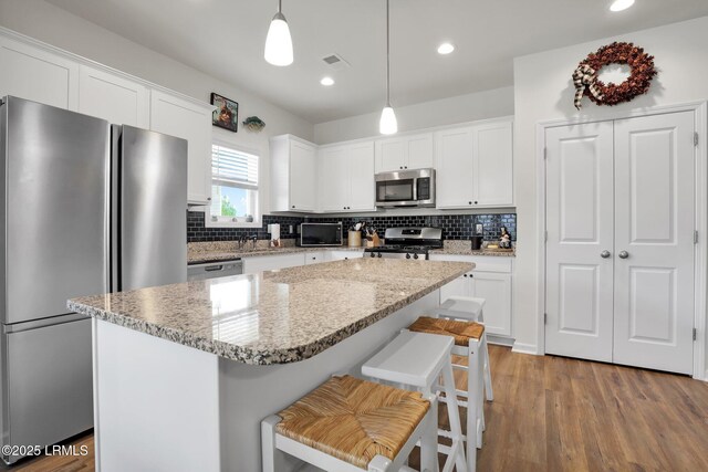 54 Great Bend Dr, Beaufort, SC 29906 - kitchen with white cabinets, tasteful backsplash, wood finished floors, and appliances with stainless steel finishes