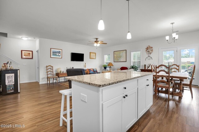 54 Great Bend Dr, Beaufort, SC 29906 - kitchen featuring pendant lighting, ceiling fan with notable chandelier, white cabinets, a kitchen island, and dark wood-style floors