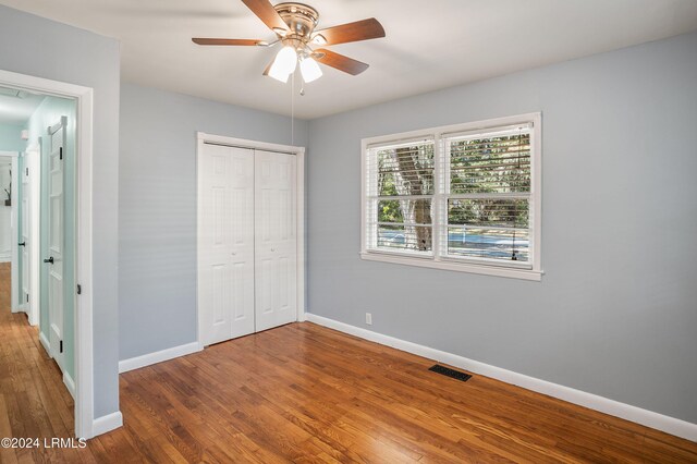 unfurnished bedroom with wood-type flooring, a closet, and ceiling fan