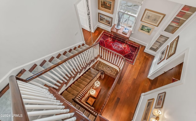 stairway featuring a towering ceiling and hardwood / wood-style floors