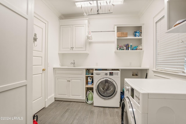 laundry room featuring sink, washer and clothes dryer, ornamental molding, and cabinets