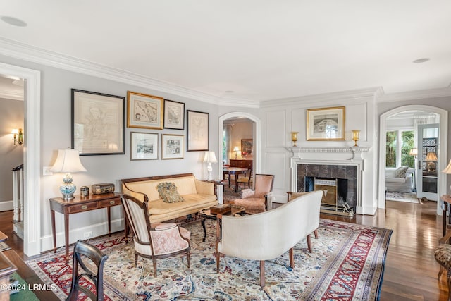 living area featuring dark hardwood / wood-style floors, a fireplace, and crown molding