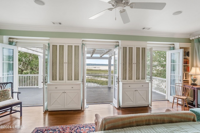 doorway featuring ceiling fan, ornamental molding, and wood-type flooring