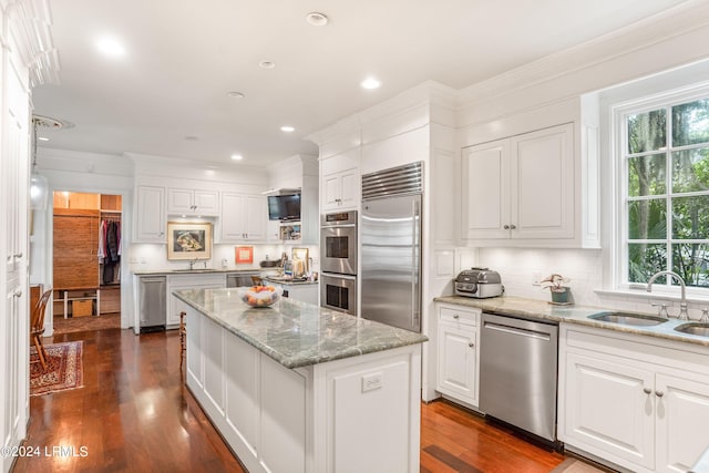 kitchen featuring sink, dark hardwood / wood-style floors, a kitchen island, stainless steel appliances, and white cabinets