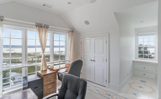 home office with vaulted ceiling and a water view